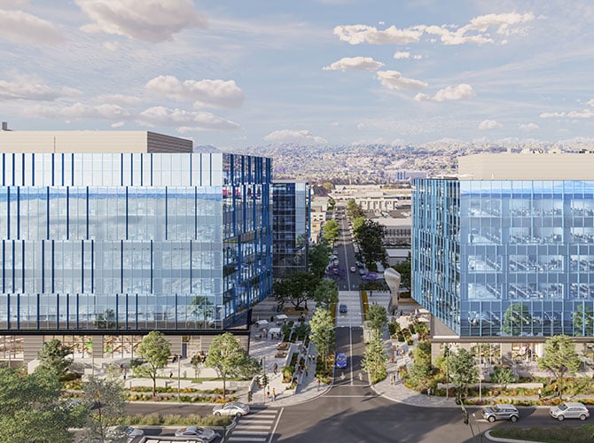 Drone view of two blue glass office buildings overlooking a bay