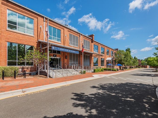 Sidewalk view of a red brick life science corporate office