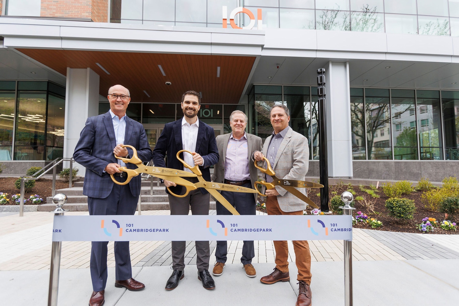 4 corporate men standing together at a ribbon cutting ceremony