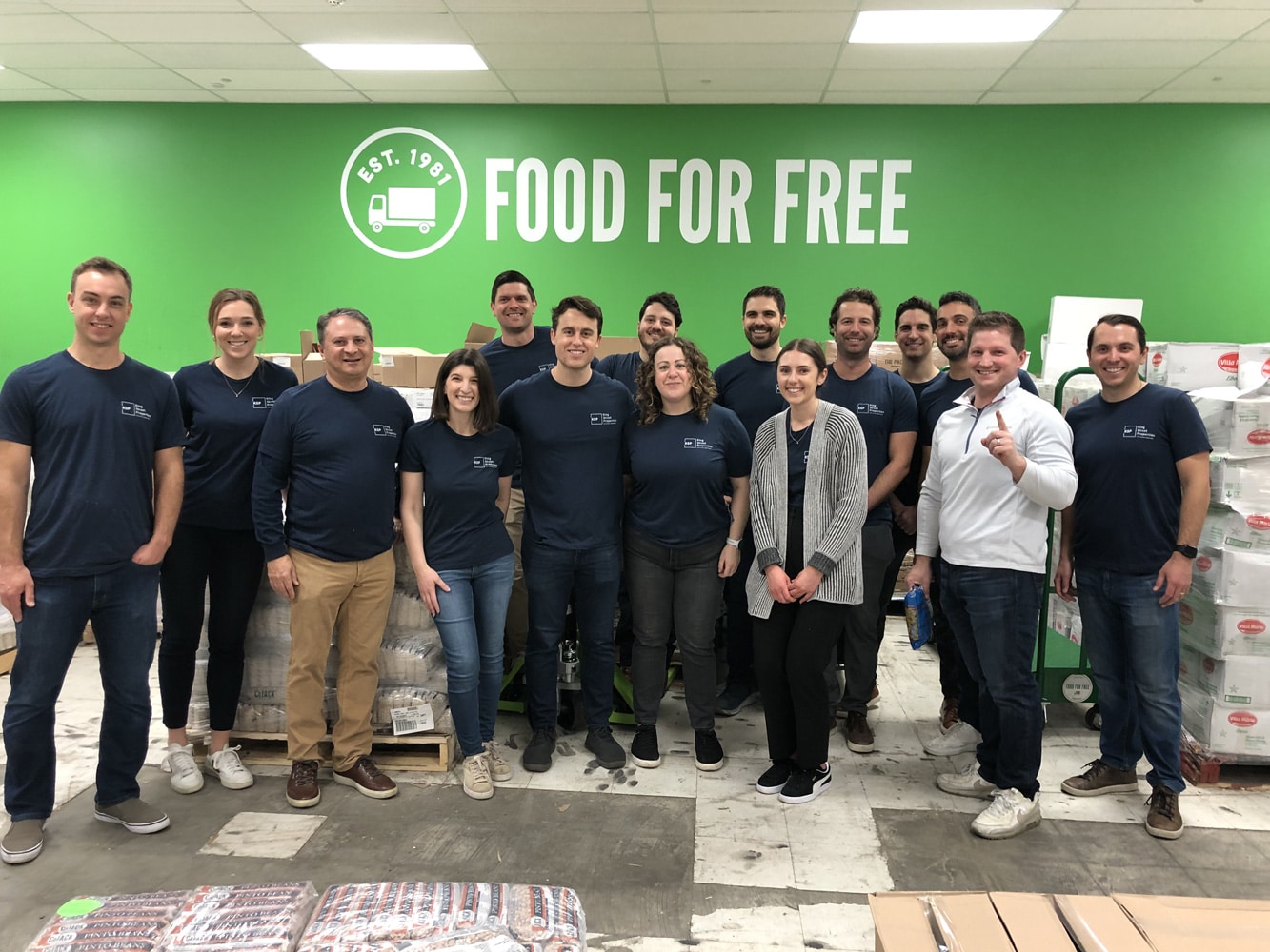 A corporate group of team members volunteering at a food bank