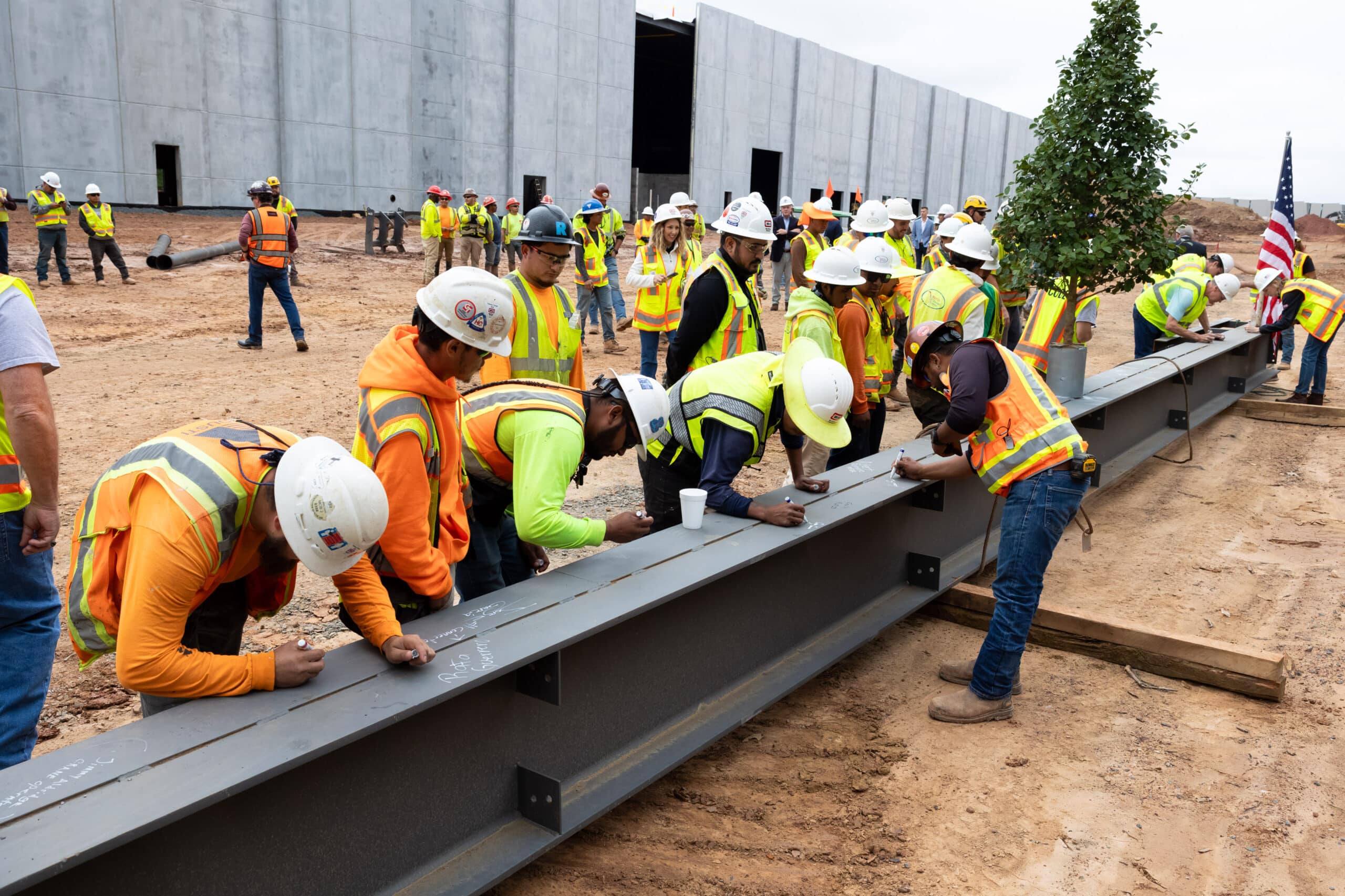 construction workers signing steel beam | Pathway Triangle